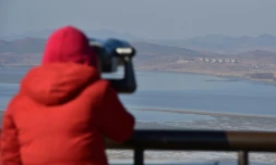 Un visiteur regarde grâce à des jumelles la Corée du Nord depuis Paju point d'observation dans la zone démilitarisée entre les deux Corée, le 8 janvier 2016