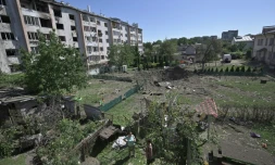 Des résidents observent le 15 août 2023 à Lviv en Ukraine un cratÚre causé par un missile tombé entre des immeubles résidentiels et un jardin d'enfants