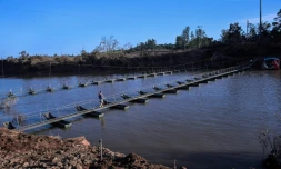 Un homme traverse la rivière Forqueta sur une passerelle flottante, à Lajeado, au Brésil, le 21 mai 2024