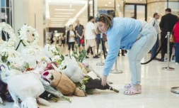 Une femme rend hommage aux victimes de l'attaque meurtriÚre du centre commercial Westfield Bondi Junction à Sydney lors de sa réouverture le 18 avril 2024, une semaine aprÚs le drame