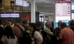 Des voyageurs consultent un panneau d'information sur les vols annulés d'Air Canada à l'aéroport Pierre-Elliott Trudeau à Montréal, au Québec, le 17 août 2025 au Canada