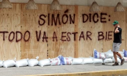 Un homme passe devant un message: "Simon a dit: +tout va bien se passer+", peint sur des planches de protection en prévision de l'arrivée du cyclone Simon à Puerto Vallarta au Mexique, le 10 octobre 2026