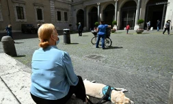 Une femme et son chien se reposent sur la place Santa Maria Ă Trastevere, Ă Rome, le 3 mai 2020.