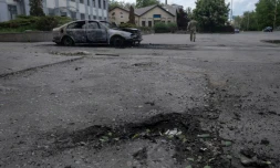 Photo prise le 16 mai 2025 et publiée le 17 mai 2025 par le service de presse de la 93e brigade mécanisée séparée de Kholodnyi Yar des forces terrestres ukrainiennes montrant un cratère à côté d'une voiture calcinée et le corps d'une victime à l'intérieur après une attaque de drone à Kostyantynivka, dans la région de Donetsk
