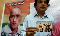 Des amis indiens de Kulbhushan Jadhav, condamnĂ© Ă mort au Pakistan, avec une photo oĂč il figure en leur compagnie, Ă Mumbai le 18 mai 2017