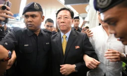 L'ambassadeur expulsé de la Corée du Nord, Kang Chol (c) escorté par des policiers dans le hall de départ de l'aéroport de Kuala Lumpur, en Malaisie, le 6 mars 2017