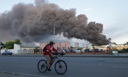 Une femme sur un vélo passe devant un entrepôt visé par une frappe russe à Odessa, le 16 juillet 2022 