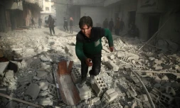 Un jeune syrien cours dans une rue d'une localité dans l'enclave rebelle de la Ghouta orientale, aprÚs un bombardement du régime, le 8 février 2018