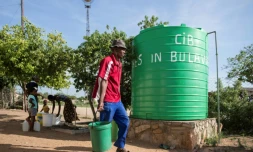 Un homme transportant un seau d'eau en périphérie de Bulawayo le 24 novembre 2016