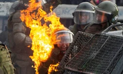 Une policiĂšre atteinte par un cocktail molotov pendant une manifestation Ă Santiago du Chili, le 4 novembre 2019
