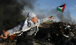 Un militant palestinien affronte les forces de sécurité israéliennes le 18 décembre 2015 sur la frontière entre Israël et la bande de Gaza 
