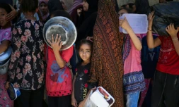 Des enfants attendent dans un centre de distribution d'aide humanitaire à Nousseirat, dans le centre de la bande de Gaza, le 2 juin 2025