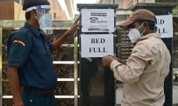 Un agent de sécurité affiche un message prévenant que plus aucun lit n'est disponible, dans un h?'pital privé d'Allahabad (Inde) le 22 avril 2021