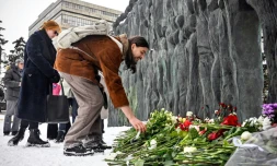 Des gens déposent des fleurs en hommage à l'opposant russe Alexeï Navalny devant le momument en mémoire des victimes de la répression politique, le 17 février 2024 à Moscou 