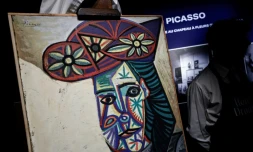 Un employé de l'Hôtel Drouot dévoile le tableau de Pablo Picasso "Buste de femme au chapeau à fleurs" représentant Dora Maar, le 18 septembre 2025 à l'Hôtel Drouot à Paris, avant la mise aux enchères de l'oeuvre le 24 octobre 2025
