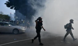 Des photographes fuient les gaz lacrymogÚnes tirés par la police, à Hong Kong le 27 octobre 2019