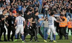 les joueurs de Lyon Rafael da Silva (d) et Jordan Ferri (g) sont protégés par le staff lyonnais lors des échauffourées à la mi-temps du match contre Bastia, le 16 avril 2017 à Furiani