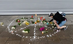 Une femme dépose une bougie à l'endroit où s'est produite une attaque mortelle au couteau, le 29 juillet 2017 à Hambourg