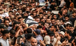 Des Palestiniens portent le corps de deux victimes des frappes israéliennes à Gaza, le 5 août 2022