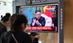 Des passants regardent des images d'archives du dirigeant nord-coréen Kim Jong Un, dans une gare de Séoul, le 21 avril 2020