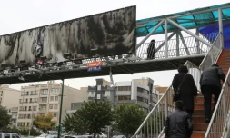 Image prise à Téhéran le 19 novembre 2019, montrant un grand panneau publicitaire au-dessus d'une autoroute urbaine incendié.