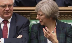 Le ministre chargé du Brexit, David Davis (G), discute avec la Première ministre Theresa May à l'ouverture des discussions devant la Chambre des Communes, le 31 janvier 2017