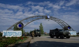 Des véhicules militaires russes passent l'entrée de la centrale nucléaire de Zaporijjia, le 1er mai 2022 à Energodar