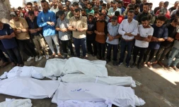 Des Palestiniens se recueillent devant des corps enveloppés dans des draps blancs, le 3 juillet 2025 dans la ville de Gaza