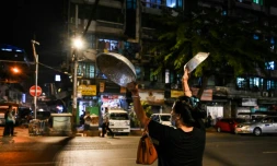 Une femme fait du bruit avec des ustensiles de cuisine pour protester contre le coup d'Etat en Birmanie, à Rangoun, le 3 février 2021