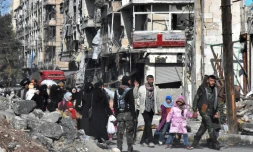 Des Syriens retournent chez eux dans un district repris par les forces gouvernementales à Alep, le 8 décembre 2016