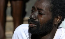 Amara, un migrant du Mali pleure en racontant son histoire dans un foyer de fortune dans la ville de Bani Walid en Libye, le décembre 2017