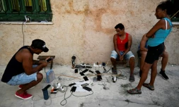 Des habitants rechargent leurs téléphones portables à La Havane pendant une panne de courant à Cuba, le 15 mars 2025