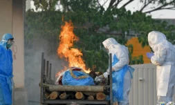 Des proches d'une personne décédée du Covid-19 appliquent un rite funéraire dans un crématorium de Bangalore, en Inde, le 26 avril 2021