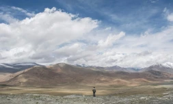Photo archive montrant un homme regardant une portion de la route de l'amitié entre la Chine et le Pakistan (à droite) et la montagne Karakorum près de Tashkurgan dans la province chnoise du Xinjiang, le 28 juin 2017