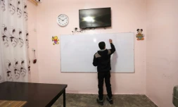 Un adolescent écrit sur un tableau au centre "Hori" pour anciens enfants jihadistes géré par les forces kurdes à Tal Maarouf, dans le nord-est de la Syrie, le 11 février 2018