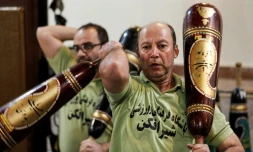 Des Iraniens s'entraînent avec des sortes de massues pour la pratique d'un sport traditionnel, dans le gymnase "zourkhaneh" (maison de force) à Téhéran le 27 février 2018