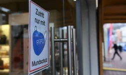 Une affiche rappelant de porter un masque de protection à l'entrée d'une boutique, le 24 novembre 2021 à Muhldorf am Inn, en Allemagne