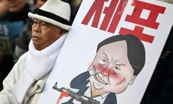 Un manifestant brandit une caricature du président sud-coréen déchu Yoon Suk Yeol, le 3 janvier 2024 à Séoul