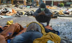 Un survivant du tsunami devant le corps de sa femme retrouvé parmi des dépouilles, le 2 octobre 2018 à Palu, ville indonésienne frappée par un séisme et un tsunami

