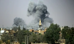 De la fumée s'échappe, au dessus de Raqa en Syrie, alors que les Forces démocratiques syriennes, formées de combattants arabes et kurdes et soutenues par Washington, tentent de reprendre la ville au groupe Etat islamique, le 14 août 2017