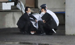 Un homme est immobilisé au sol après avoir lancé un objet ressemblant à une bombe fumigène lors d'un meeting du Premier ministre japonais, à Wakayama, au Japon, le 15 avril 2023