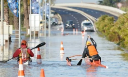 Deux hommes se déplacent en kayak sur une route inondée à Palavas-les-Flots le 23 novembre 2019