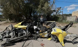 Un Palestinien prÚs de la carcasse d'une voiture détruite par un bombardement israélien à Rafah, dans le sud de la bande de Gaza, le 10 mars 2024