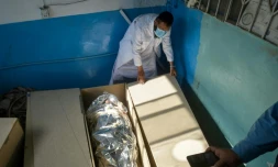 Un membre du Croissant-Rouge afghan vérifie les cercueils de membres des forces de sécurité pakistanaises avant leur remise au Pakistan, dans la morgue d'un hôpital de Spin Boldak, dans le sud de l'Afghanistan, le 15 octobre 2025