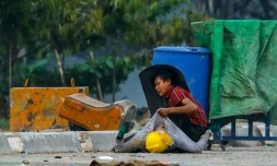 Un protestataire tient un camarade tombé lors d'affrontements avec les forces de l'ordre birmanes, à Hlaing Tharyar, dans l'agglomération de Rangoun, le 14 mars 2021