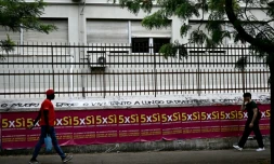 Des gens passent devant des affiches invitant à voter pour le référendum, à Rome, le 5 juin 2025
