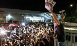 Un journaliste du Apple Daily brandit des exemplaires tout juste imprimés du dernier numéro de ce quotidien pro-démocratie à Hong Kong, le 24 juin 2021