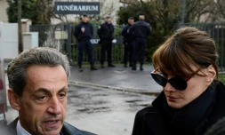 L'ancien président Nicolas Sarkozy (G) et Carla Bruni-Sarkozy parlent aux journalistes devant le funérarium du Mont-Valérien, où repose la dépouille de Johnny Hallyday, le 8 décembre 2017 à Nanterre, près de Paris