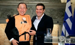 Le secrétaire général de l'ONU Ban Ki-moon (g) en gilet de sauvetage offert par le Premier ministre grec Alexis Tsipras (d) comme un  "symbole" des traversées périlleuses des migrants, le 18 juin à Athènes