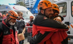 Deux secouristes turcs, Ahmet Celik (D) et Ibrahim Topal (2èG), s'étreignent après avoir sauvé une fillette de trois ans, Ayda Gezgin, des décombres le 3 novembre 2020